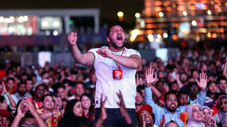 Morocco's supporters celebrate after their team won the Qatar 2022 World Cup round 16 match against Spain, at the FIFA fan zone in Doha, on December 6, 2022. (Photo by MAHMUD HAMS / AFP)