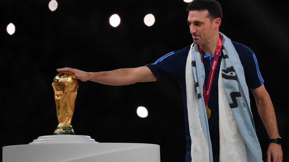 Argentina coach Lionel Scaloni touches the World Cup trophy at the Lusail Stadium on December 18: AFP/Franck Fife