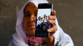 فلسطينية تعرض صورة أقاربها الذين قضوا في ليبيا