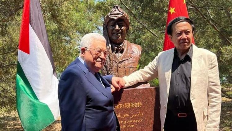 أبو مازن أمام مجسم تذكاري للرئيس الفلسطيني الراحل ياسر عرفات