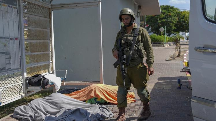 جندي إسرائيلي يقف إلى جوار جثث لإسرائيليين آخرين
